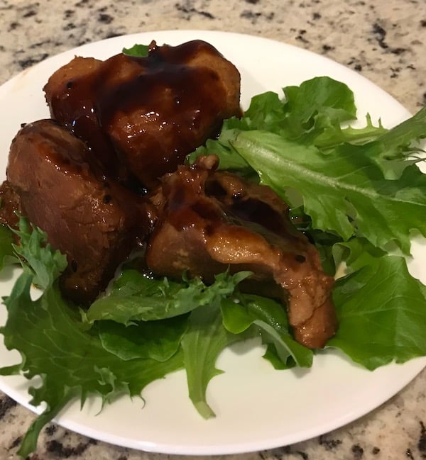 Sesame ginger ribs with sauce on a plate with lettuce